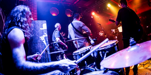 A session musician playing drums in a band.