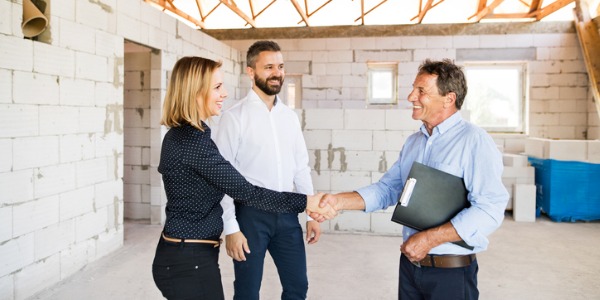 An energy auditor meeting with home owners to discuss how they can save money on their energy costs.