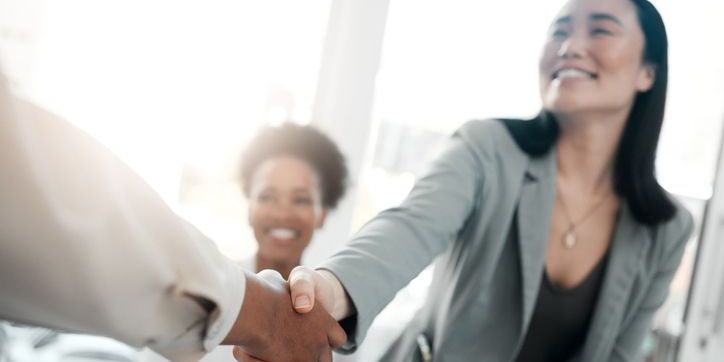 A sales representative shaking hands with a potential customer.