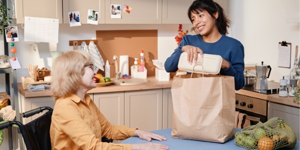 An occupational therapist helping a patient with her groceries.