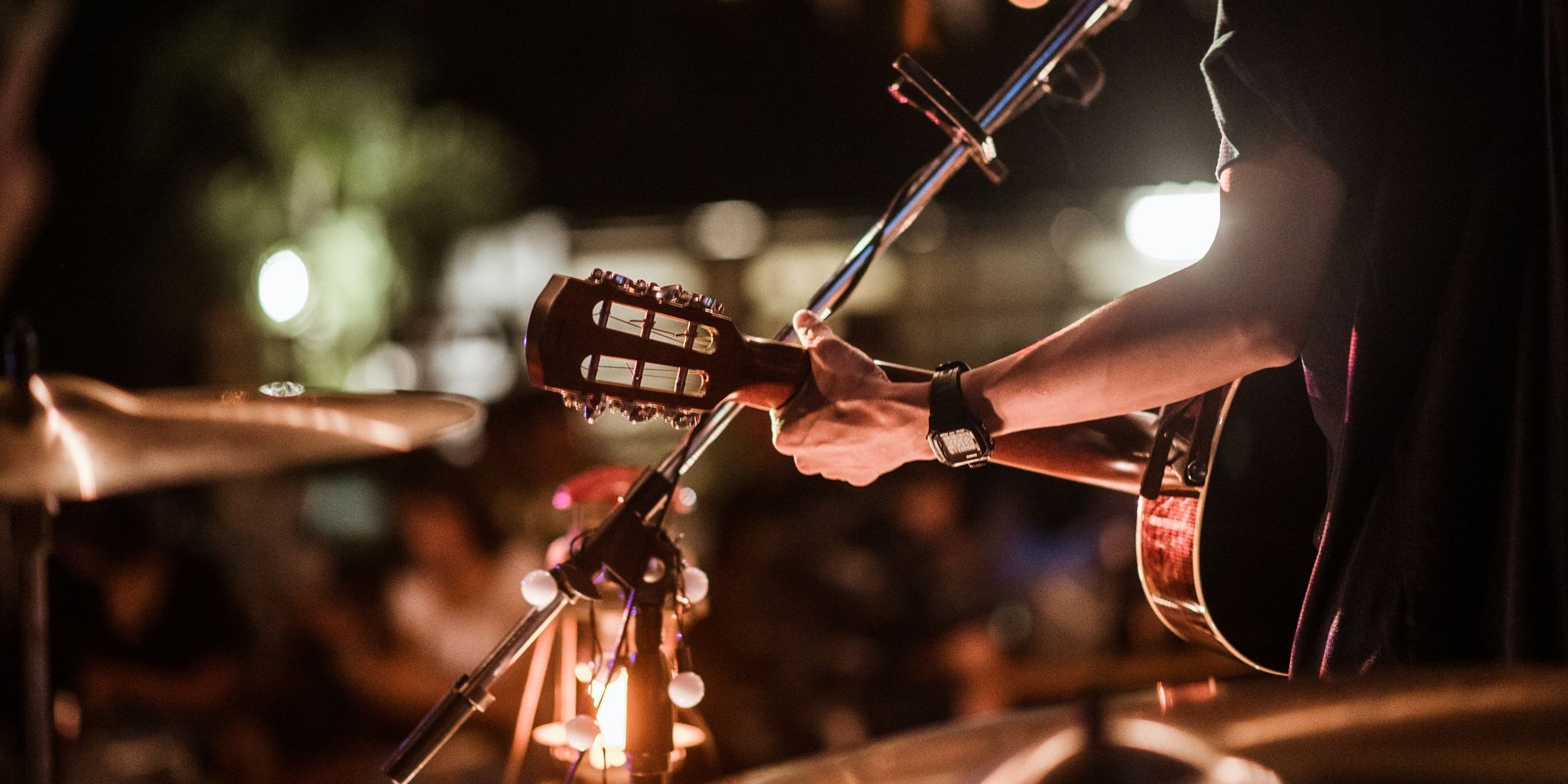 A musician playing the guitar on stage.