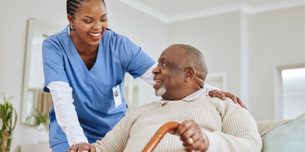 A home health nurse smiling at her patient.