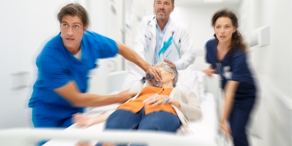Trauma nurses running down the hospital hallway with a patient on a gurney.