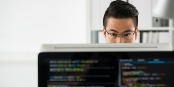 A cryptanalyst working on a computer and developing codes that protect data from computer hackers.
