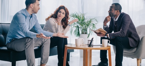 A marriage therapist having a counseling session with a husband and wife.